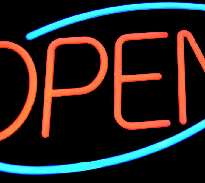 A cropped shot of an open sign lit in blue and red.