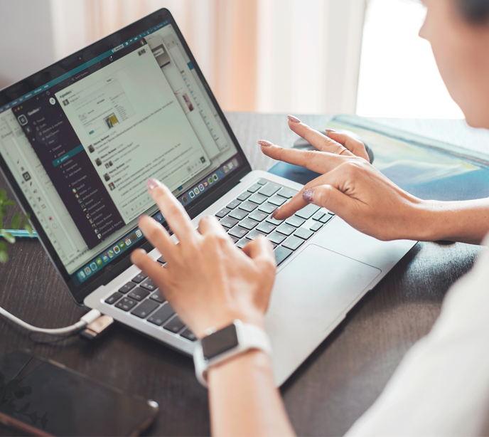 A woman typing on a laptop keyboard.