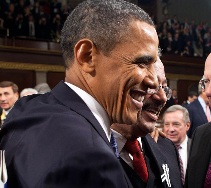 Barack Obama in a court room smiling for a photo with other people around him.