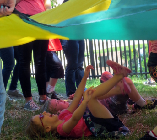 Children play with the parachute during Fun Friday!