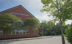 Lighthouse Autism Center building with green trees.