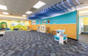 A wide angle view of a room at the Lighthouse Autism Center as a grocery store with a trampoline and other toys