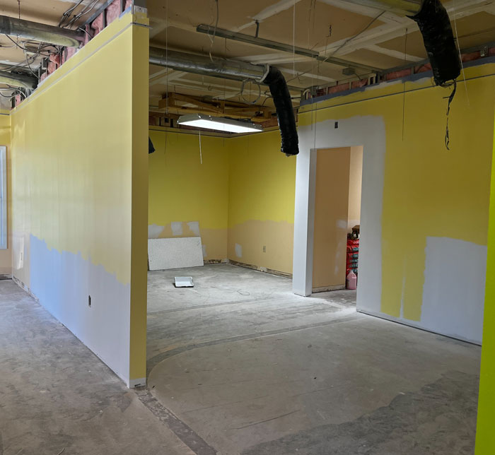 A room at the Castleton Autism Center with silver pipes hanging from the ceiling and yellow walls with white on the edge