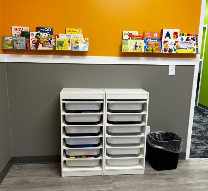 Low angle shot of orange and gray wall in Kalamazoo East Autism Center Therapy Room with white plastic shelves