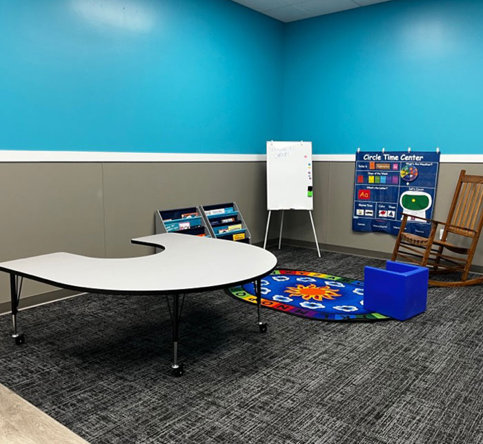 A therapy room with a round table and circle time to practice school skills at Lighthouse Autism Center