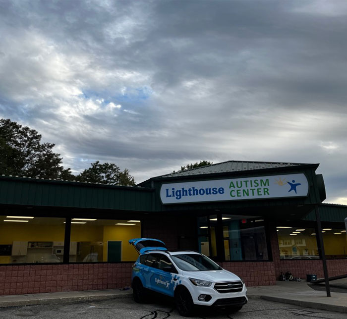 The front entrance of Kalamazoo East Lighthouse Autism Center with a branded truck parked in front