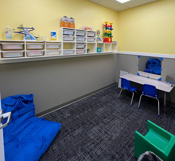 A therapy room at Kalamazoo East Center with plastic drawers, a large blue bean bag and gray table