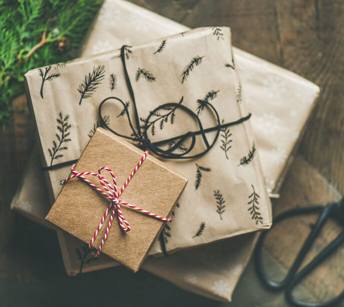 A pile of three different size gifts wrapped in brown paper