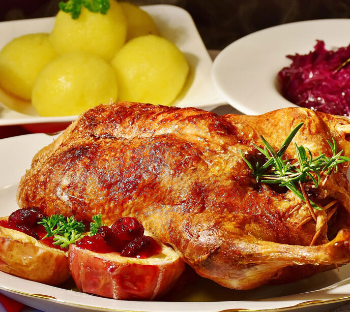 A roasted chicken with potatoes and red currant sauce