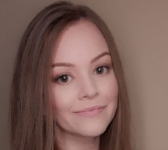 A portait of a woman with brown hair smiling