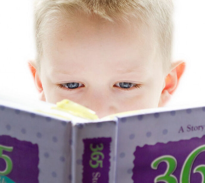 A close up shot of a child's eyes reading a book