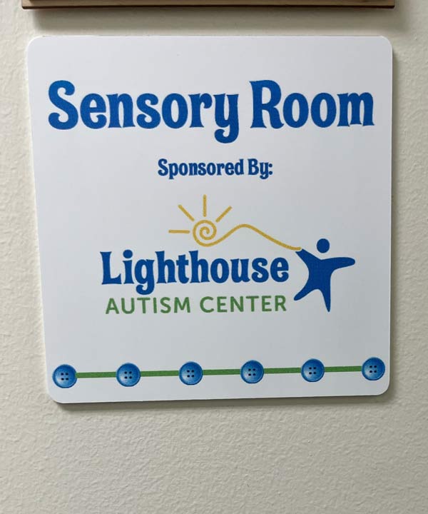 A room sign reading "Sensory room sponsored by Lighthouse Autism Center" with the LAC logo at the bottom.