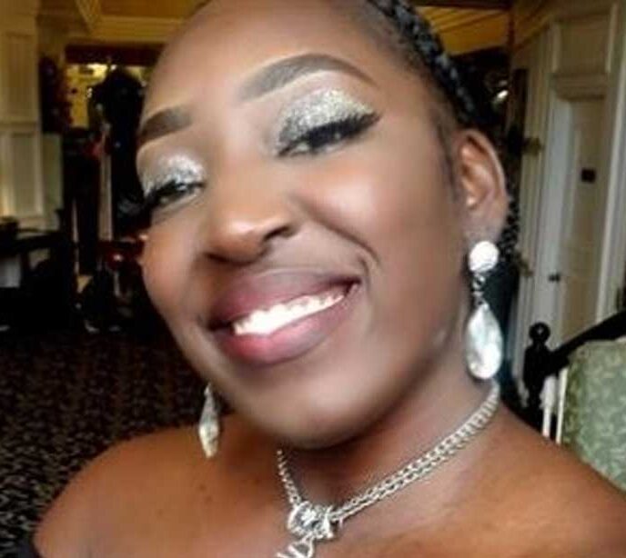 A selfie of a female Lighthouse Autism Center employee smiling wearing large silver earrings and a necklace